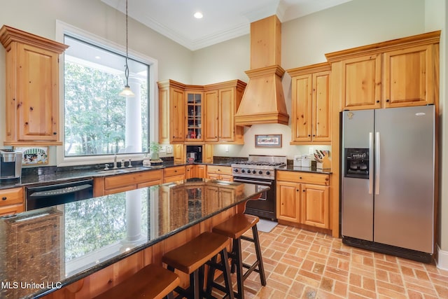 kitchen featuring stainless steel fridge with ice dispenser, dishwasher, range with gas stovetop, a sink, and brick flooring