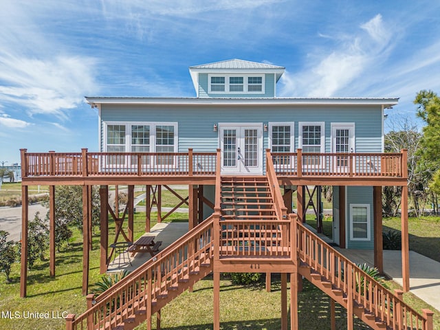 rear view of property featuring french doors, metal roof, and stairway