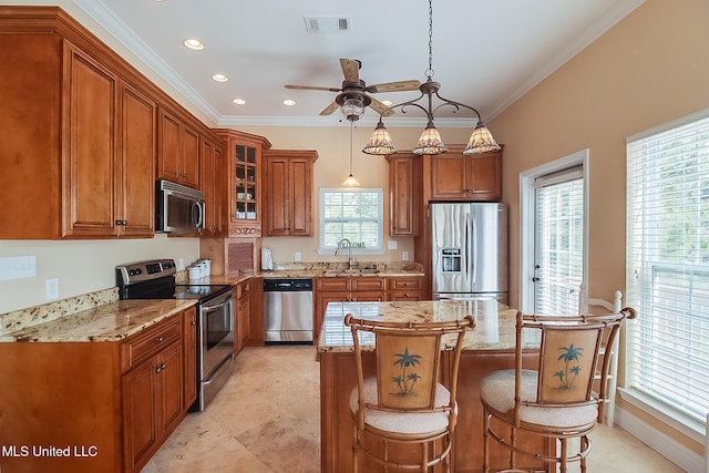 kitchen featuring stainless steel appliances, visible vents, glass insert cabinets, brown cabinetry, and a sink