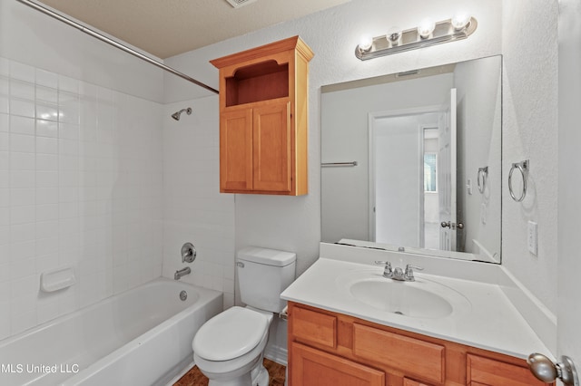 full bathroom featuring vanity, toilet, a textured ceiling, and tiled shower / bath