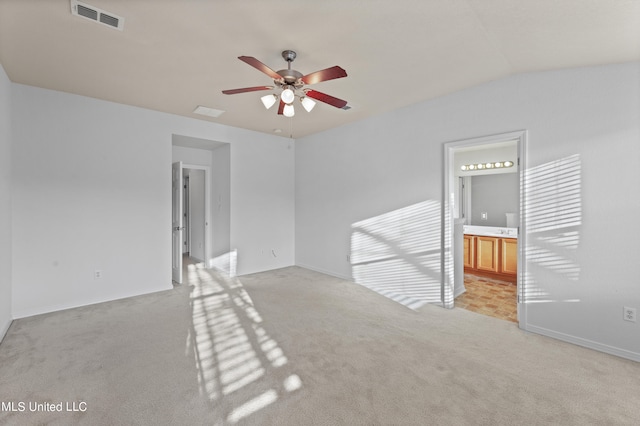 empty room featuring lofted ceiling, light colored carpet, and ceiling fan