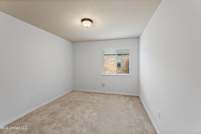 unfurnished room featuring a textured ceiling and light colored carpet