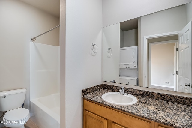 full bathroom featuring  shower combination, stacked washing maching and dryer, tile patterned flooring, vanity, and toilet