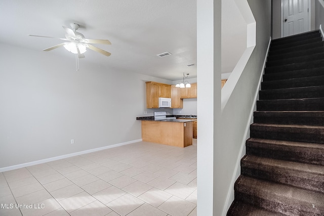 stairs featuring ceiling fan with notable chandelier and tile patterned floors