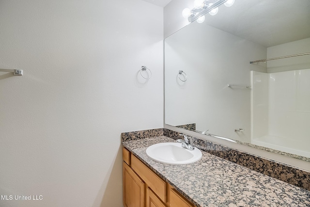 bathroom with vanity and a shower