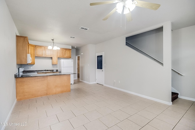 kitchen with light tile patterned floors, light brown cabinets, white appliances, and kitchen peninsula