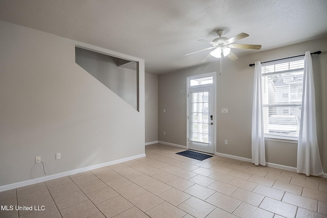 tiled entrance foyer with a wealth of natural light, a textured ceiling, and ceiling fan