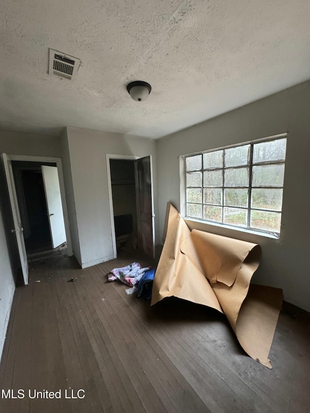 interior space with dark hardwood / wood-style floors and a textured ceiling