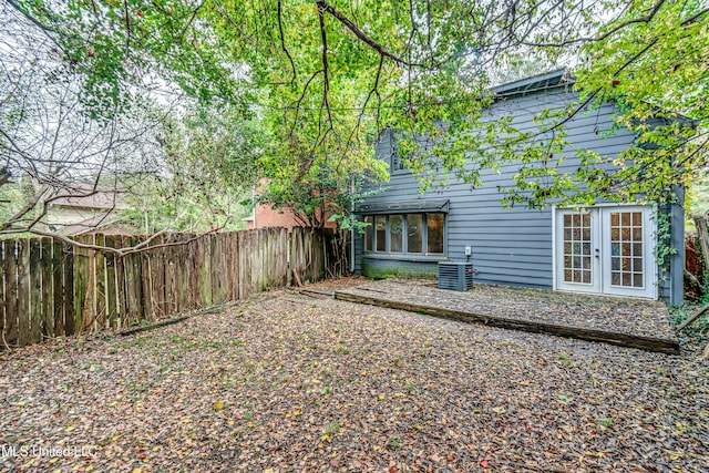 view of yard featuring central AC and french doors