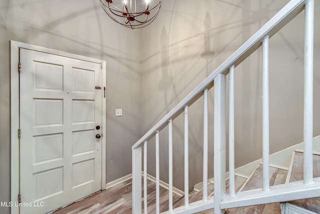 foyer entrance featuring an inviting chandelier and wood-type flooring