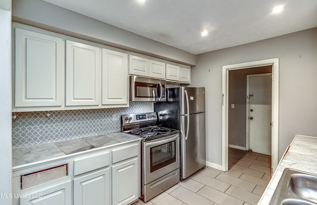 kitchen featuring white cabinetry, backsplash, and stainless steel appliances