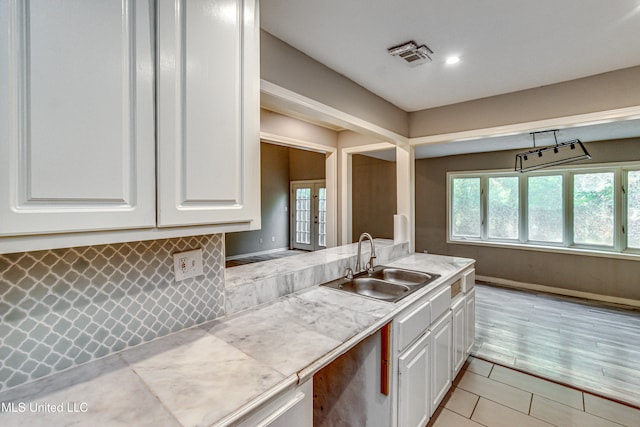 kitchen featuring white cabinets, plenty of natural light, and sink