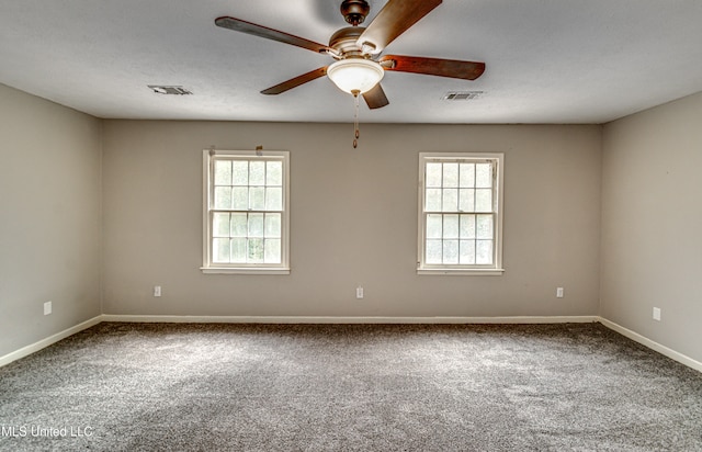 spare room with ceiling fan, plenty of natural light, and carpet floors