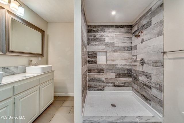 bathroom featuring vanity, tile patterned flooring, and tiled shower