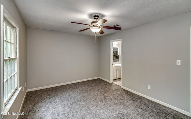 carpeted empty room with a textured ceiling and ceiling fan