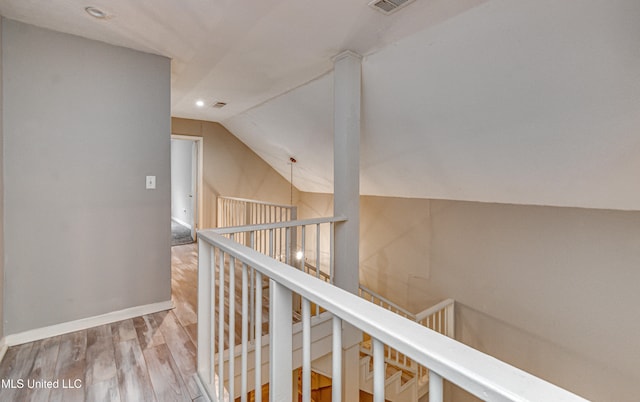 hallway featuring wood-type flooring and lofted ceiling