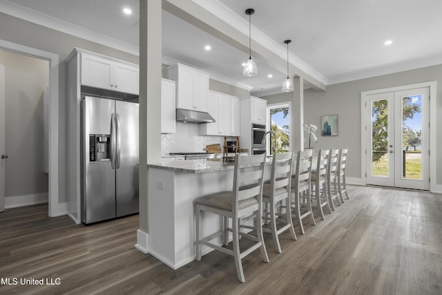 kitchen featuring a center island with sink, backsplash, dark wood-type flooring, under cabinet range hood, and stainless steel fridge with ice dispenser