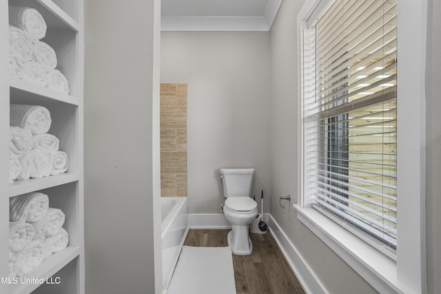 bathroom with a bathtub, a wealth of natural light, wood finished floors, and toilet