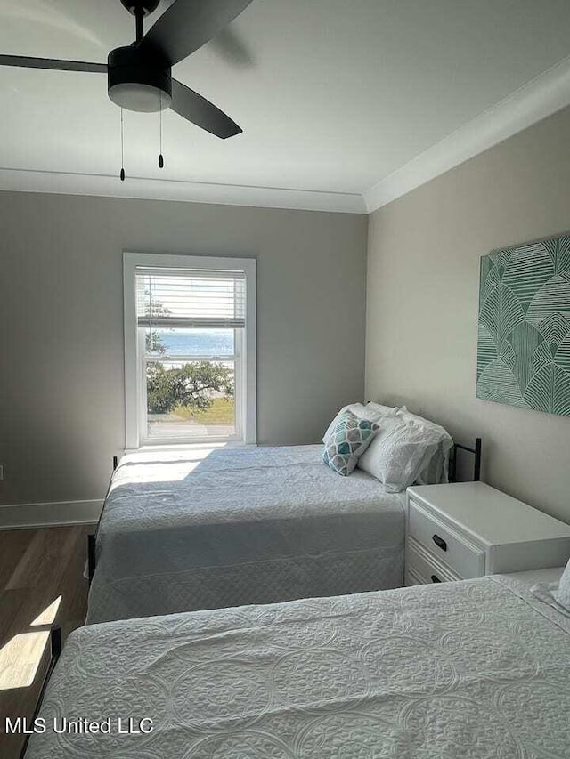 bedroom with ornamental molding, ceiling fan, baseboards, and wood finished floors