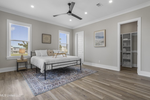 bedroom with baseboards, multiple windows, and crown molding