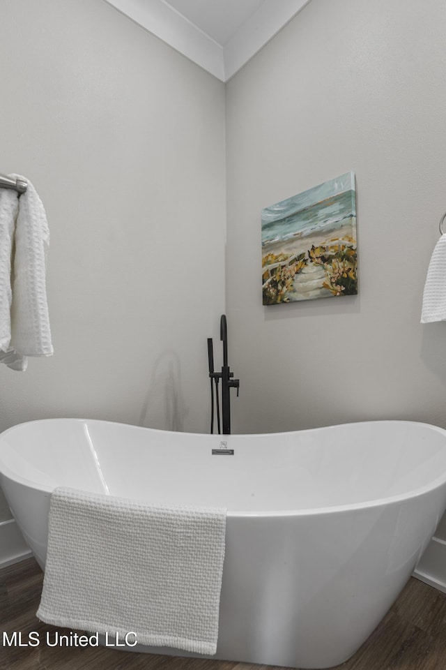 full bath featuring a freestanding bath and wood finished floors