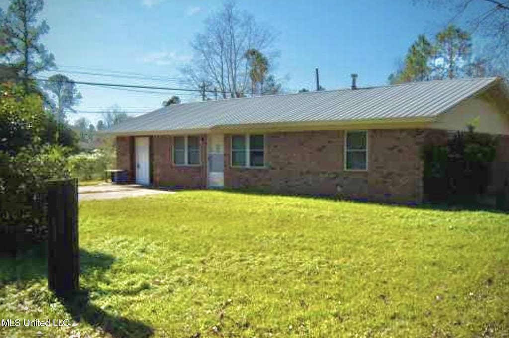 rear view of house with a yard and a garage