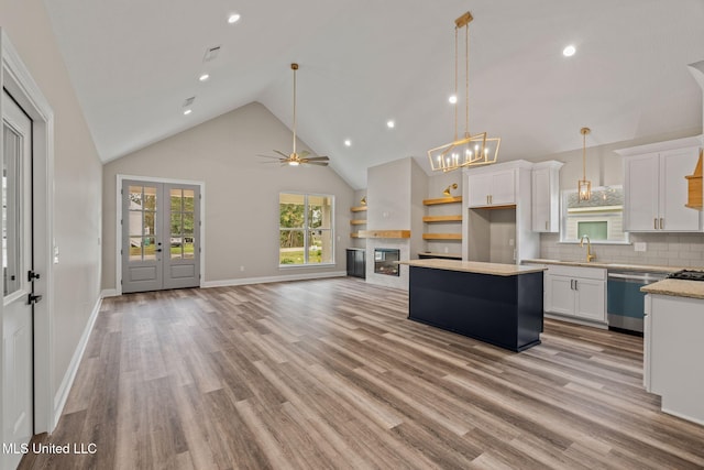 kitchen with white cabinetry, open floor plan, dishwasher, and light countertops