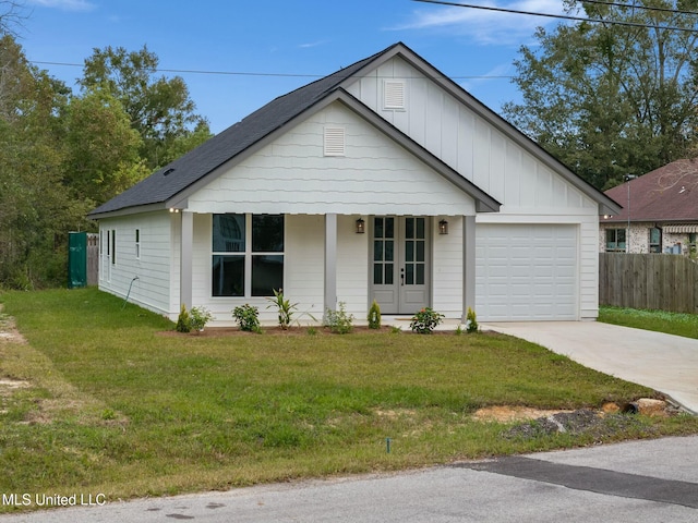 view of front of house with board and batten siding, a front yard, and driveway