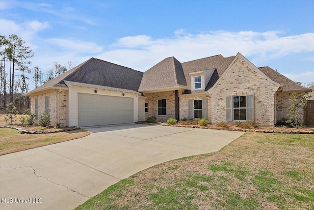 french country home featuring a garage, driveway, a front lawn, and brick siding