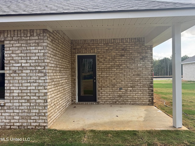 view of exterior entry with a patio area