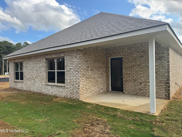 back of house with a patio and a lawn