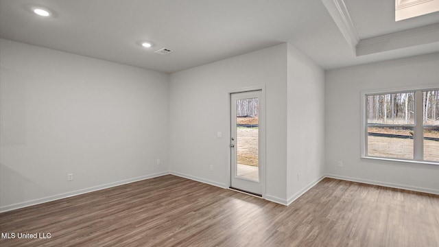 empty room featuring crown molding and wood-type flooring