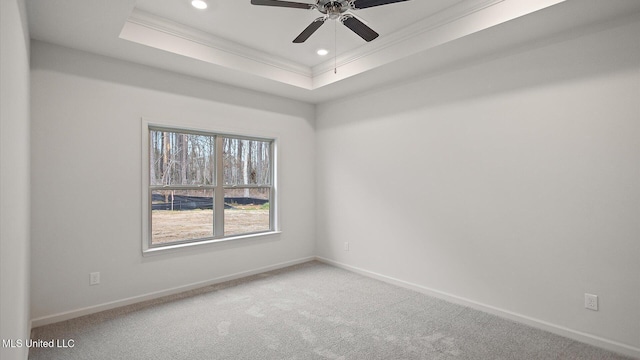 unfurnished room featuring a tray ceiling, ornamental molding, ceiling fan, and carpet