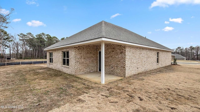 view of side of property with a patio area and a lawn