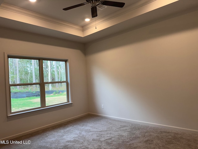 empty room featuring crown molding, ceiling fan, a tray ceiling, and carpet floors