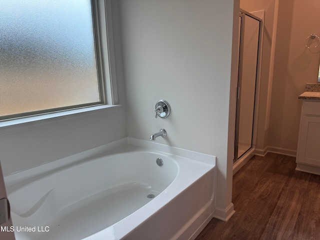 bathroom with hardwood / wood-style flooring, shower with separate bathtub, and vanity