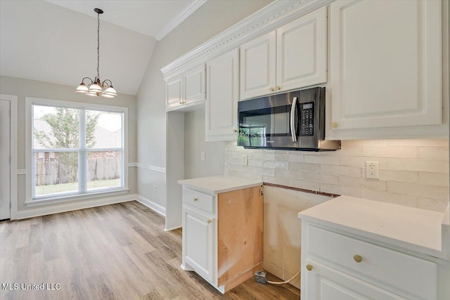 453 Abbey Woods, Brandon, MS 39047 - kitchen with stainless steel microwave, lofted ceiling, backsplash, a chandelier, and white cabinets