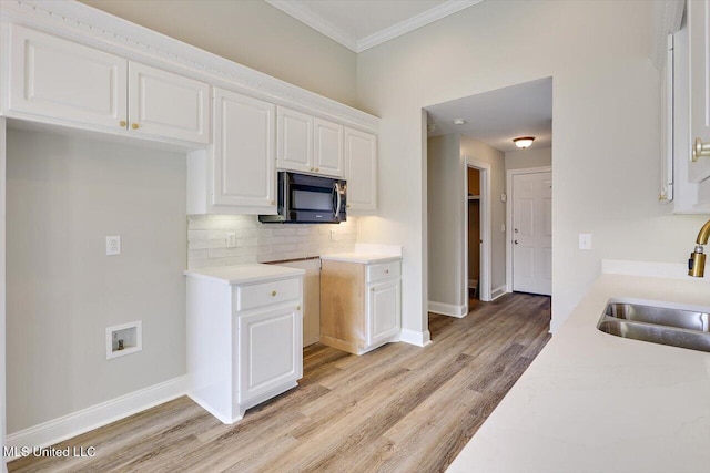453 Abbey Woods, Brandon, MS 39047 - kitchen featuring a sink, stainless steel microwave, white cabinets, light wood-style flooring, and crown molding