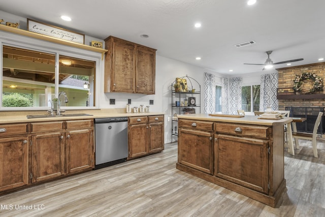 kitchen with dishwasher, light hardwood / wood-style flooring, plenty of natural light, and sink