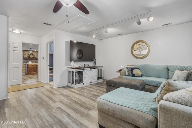 living room with ceiling fan, light hardwood / wood-style floors, and rail lighting