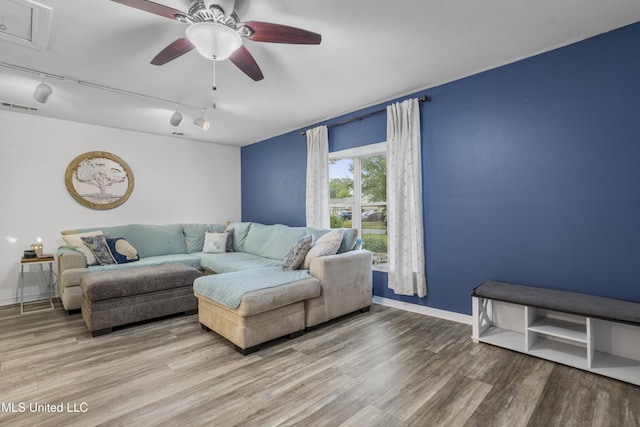 living room featuring wood-type flooring, track lighting, and ceiling fan