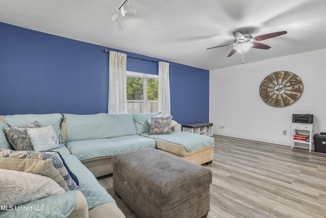 living room with light wood-type flooring and ceiling fan