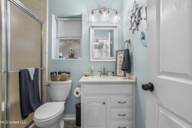 bathroom featuring vanity, toilet, and walk in shower