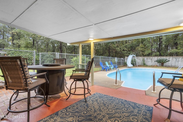 view of pool featuring a patio area and a water slide