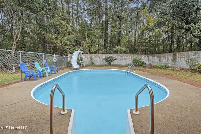 view of pool featuring a patio and a water slide