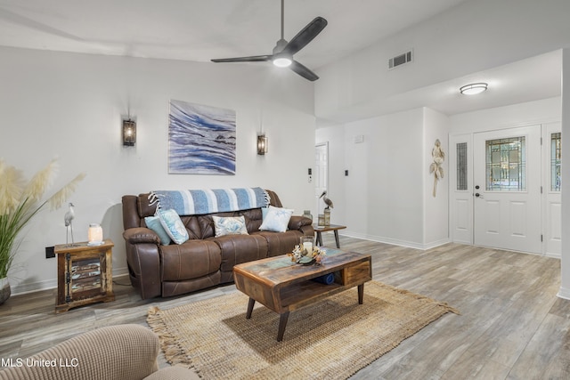 living room featuring hardwood / wood-style floors, ceiling fan, and lofted ceiling