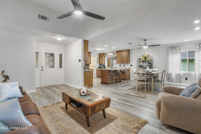 living room featuring ceiling fan and light hardwood / wood-style flooring