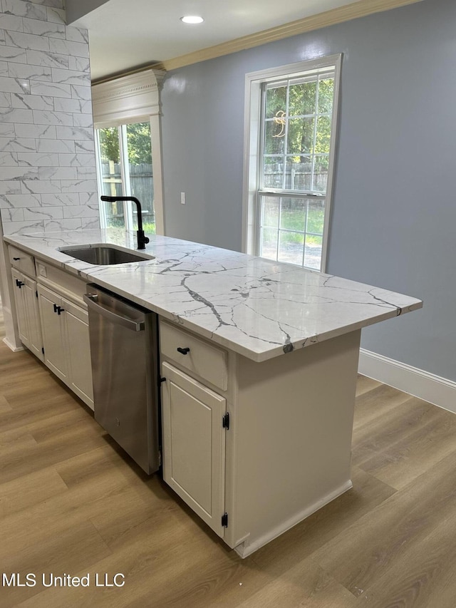 kitchen featuring backsplash, stainless steel dishwasher, white cabinets, light stone counters, and sink