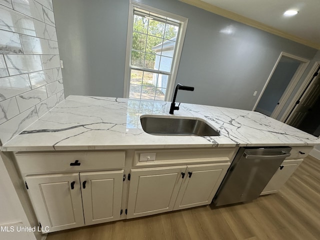 kitchen featuring light stone counters, sink, white cabinets, and stainless steel dishwasher