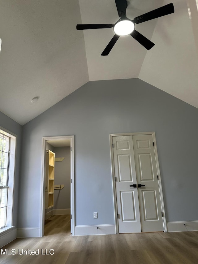 unfurnished bedroom with lofted ceiling, light hardwood / wood-style flooring, a closet, and ceiling fan